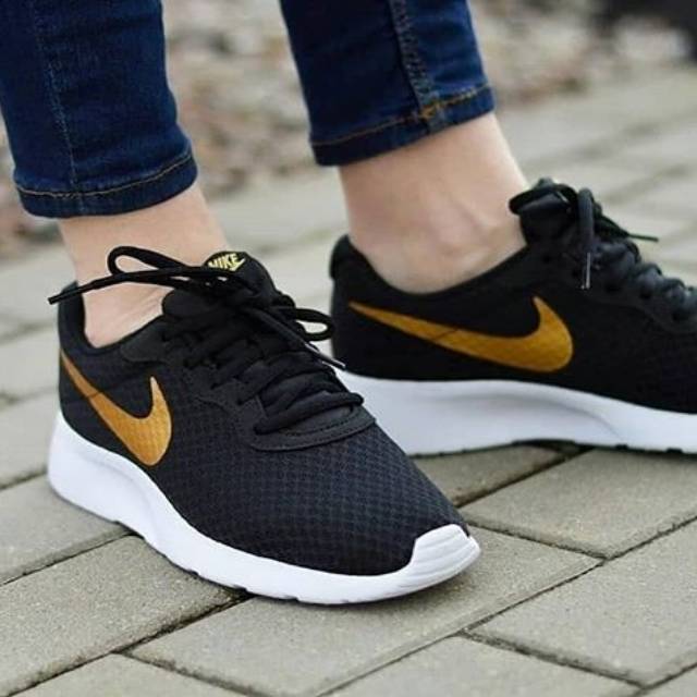 nike tanjun black and gold