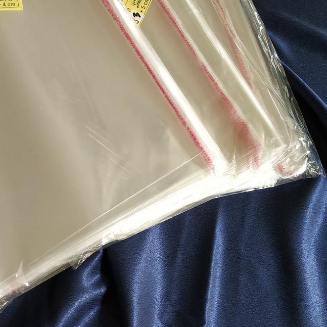 

☛ Plastik OPP 28,5 X 40 CM 20 MIC 100LBR Lem Atau Seal / Plastik bening kemasan bungkus baju gamis celana garment ♘