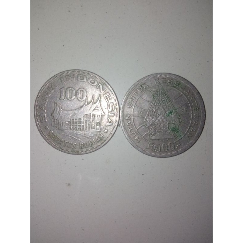uang logam 100 rupiah gambar rumah gadang dan wayang.
