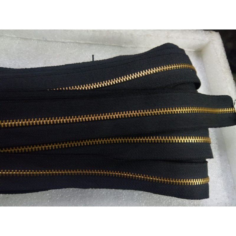

Resleting gigi besi ukuran no.5 pita hitam rel kuning (25 yard).