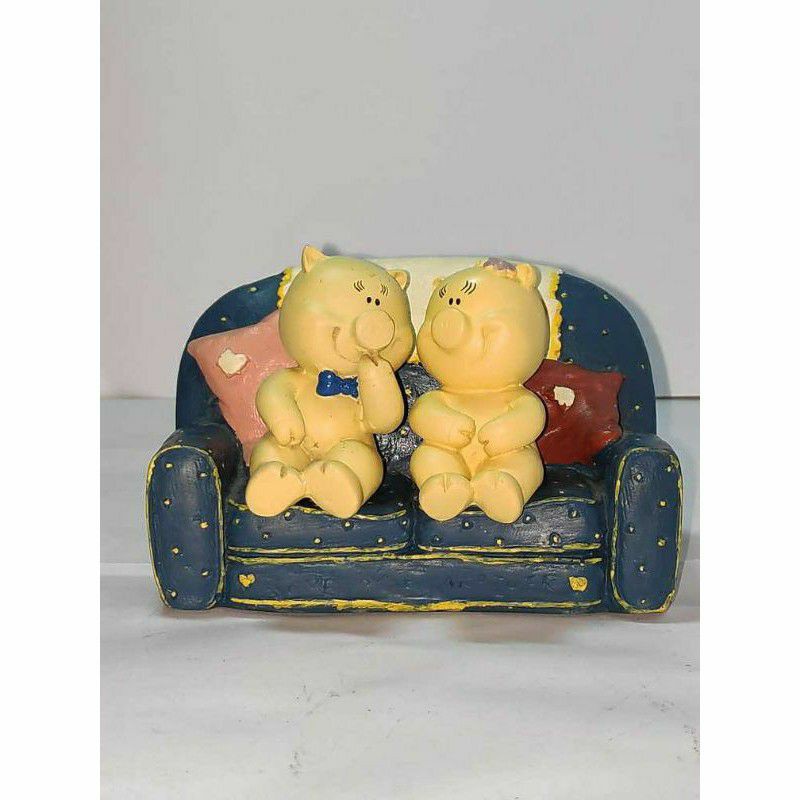 Pajangan patung unik sepasang babi lucu duduk di sofa
