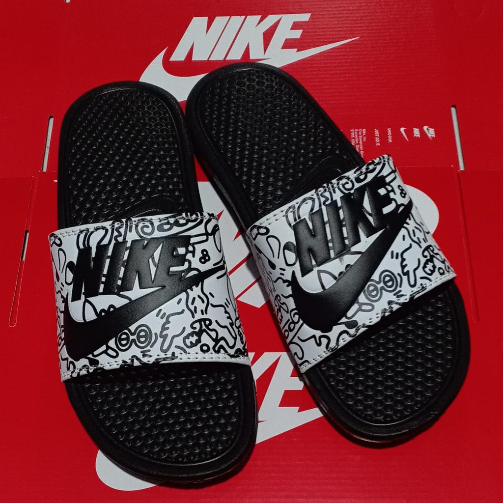 black nike slides with white swoosh