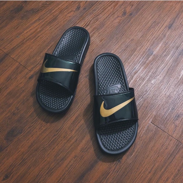 black and gold nike flip flops