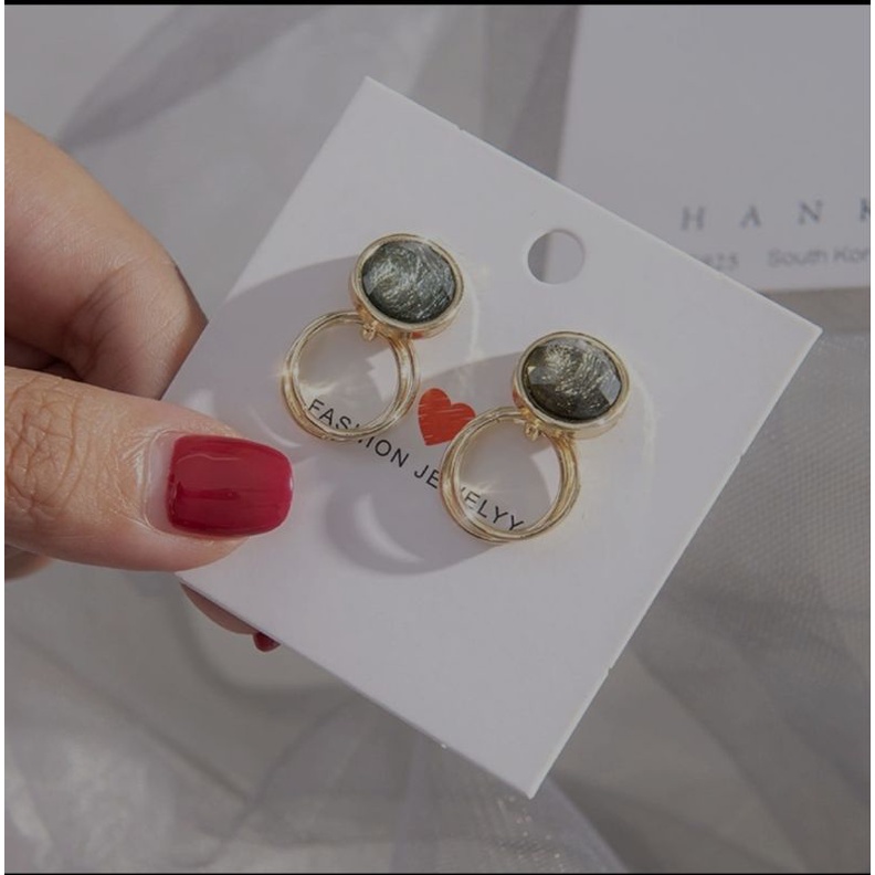 Anting tusuk motif bulat mata hijau.