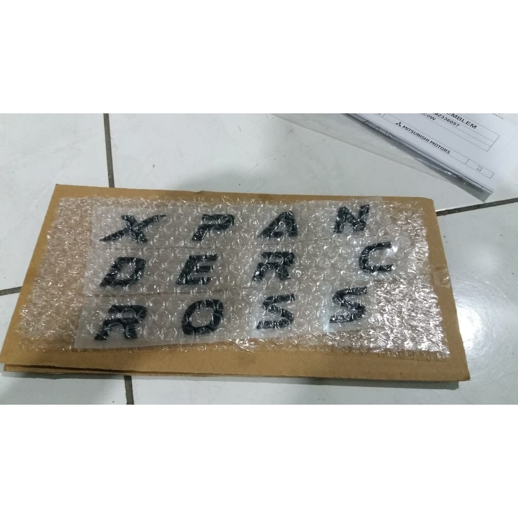 EMBLEM TULISAN XPANDER CROSS HITAM DI KAP MESIN VERSI BLACK EDITION MZ336057