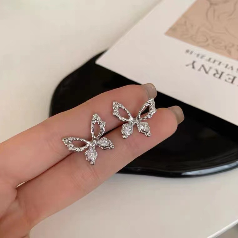 Anting Stud Desain Kupu-Kupu Hollow Aksen Kristal Warna Silver Untuk Wanita