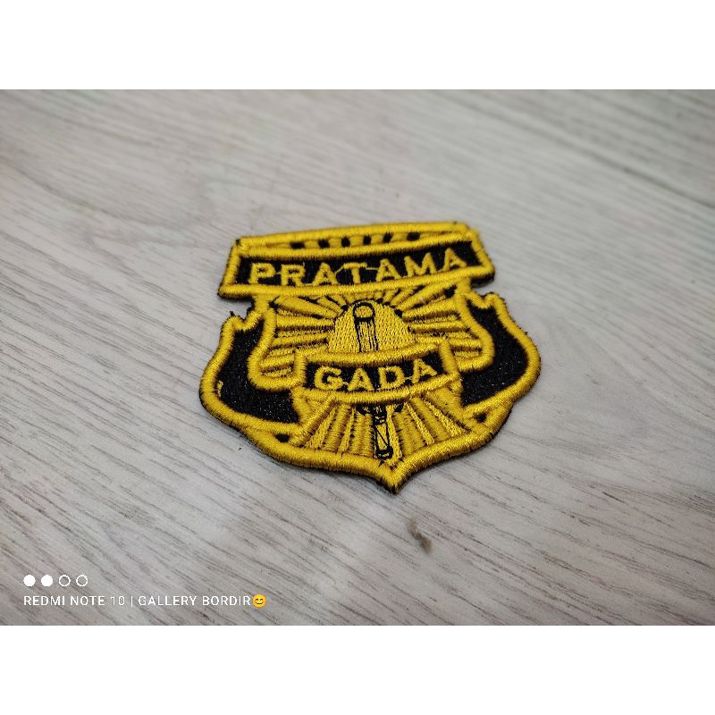 logo gada pratama kuning dongker timbul