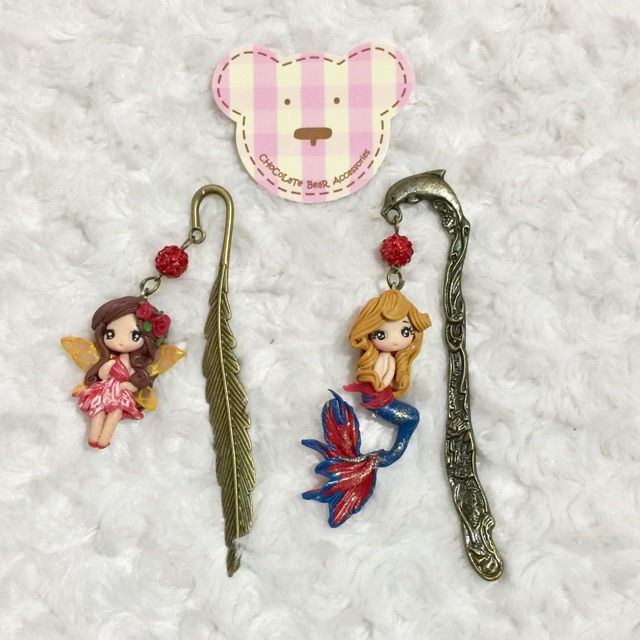 

Pembatas buku bahan logam dengan hiasan polimer clay doll