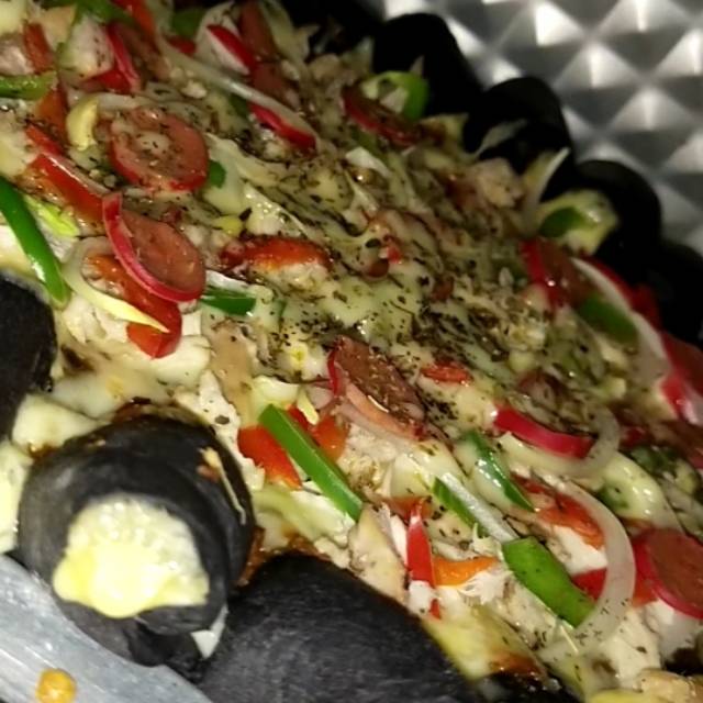 

Black pizza ayam sudah berbumbu with full mozzarela pinggiran dan dalam