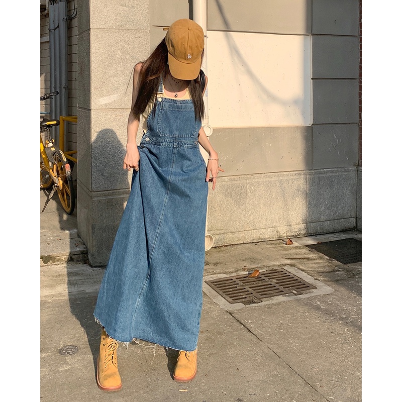 ☋△gaun musim panas pantai gaya Hong Kong retro denim suspender rok gaun perempuan musim semi biru A-line rok tepi mentah rok panjang trendi