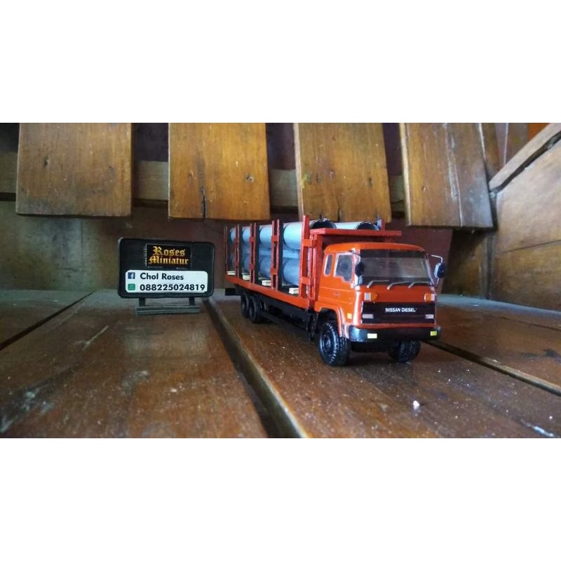 Miniatur truk Nissan diesel muatan pipa