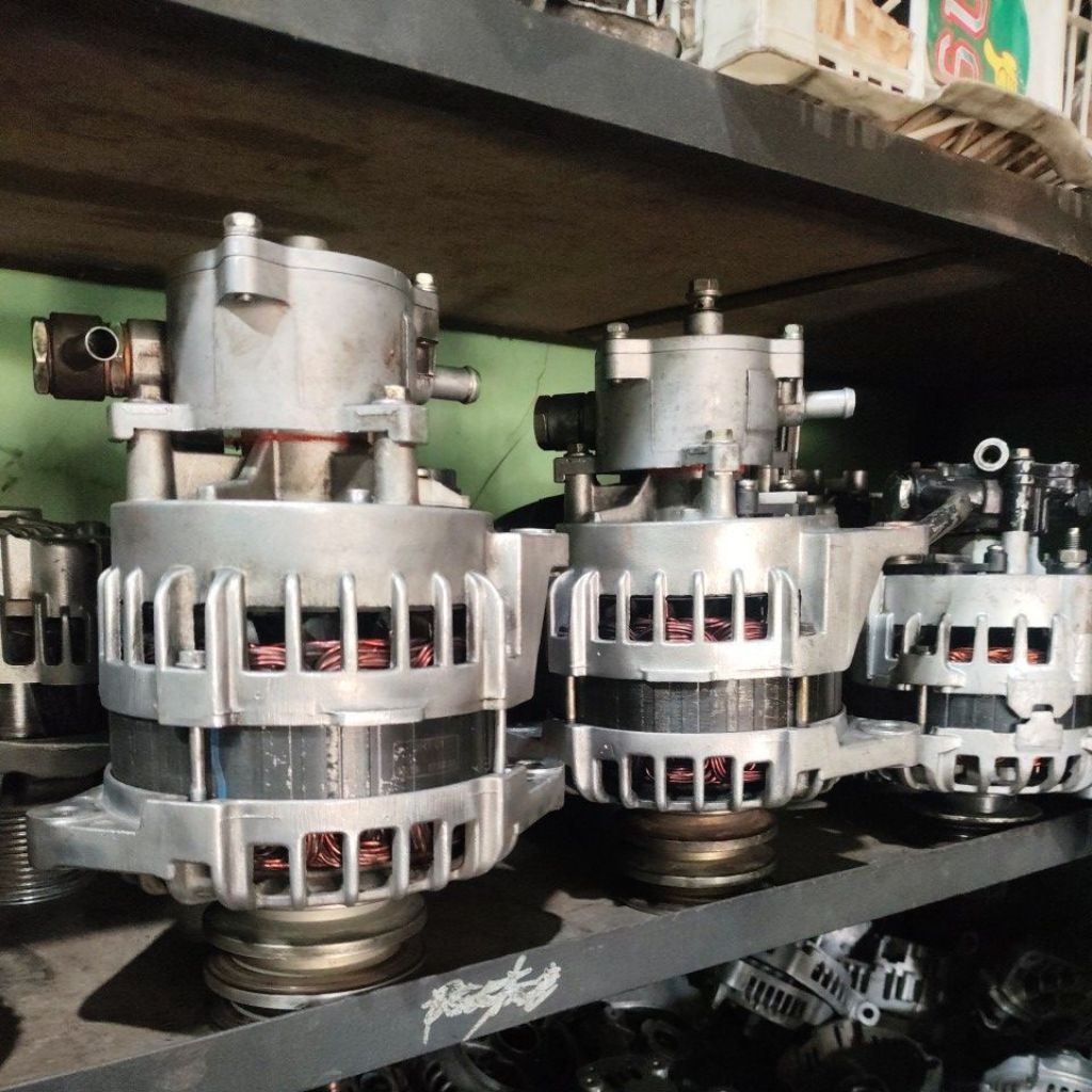 Alternator mobil bekas warna perak dengan bracket