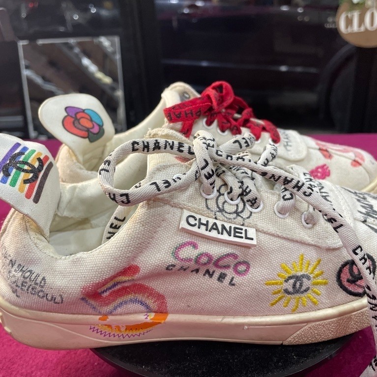Sepatu Sneakers Chanel Coco motif tulisan putih dengan tali motif dan lidah warna putih