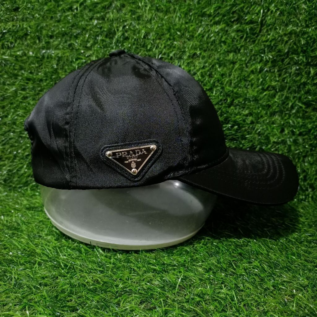 Topi baseball hitam dengan logo segitiga PRADA Milano model kasual
