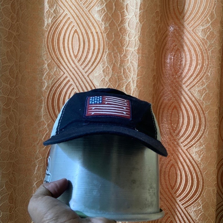 Topi baseball hitam dengan patch bendera Amerika Serikat model trucker kasual