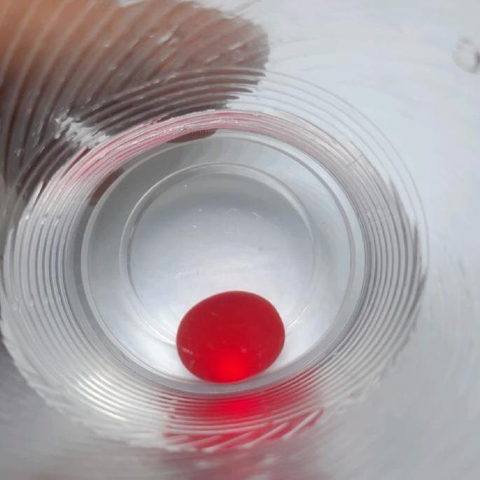 Batu merah bulat menyala dalam air