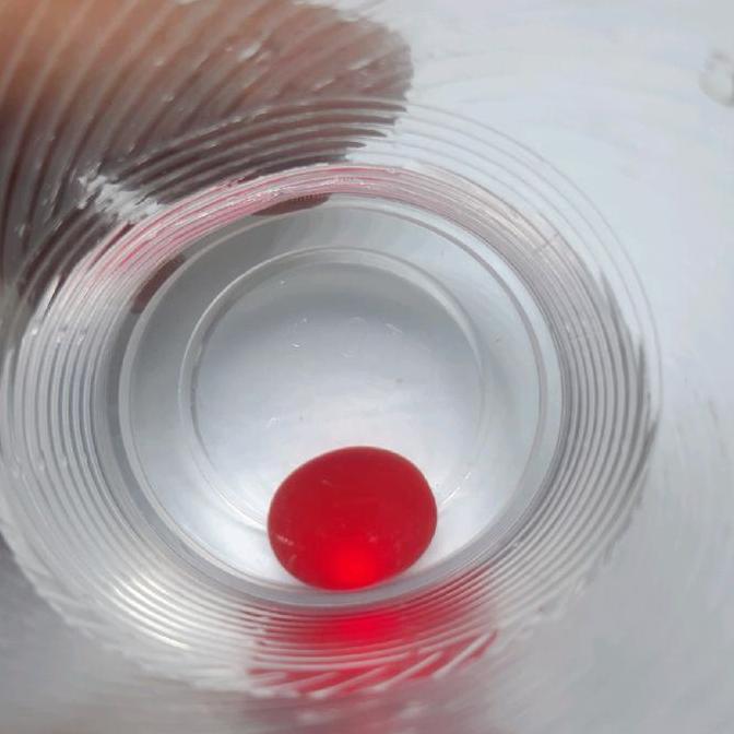 Batu merah bulat menyala dalam air