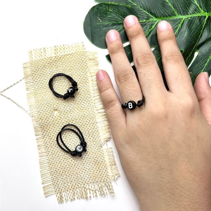 CINCIN INISIAL HURUF BULAT/BUNDAR HITAM TULISAN PUTIH TALI KOREA 1 MM  (XSEMPLAR)