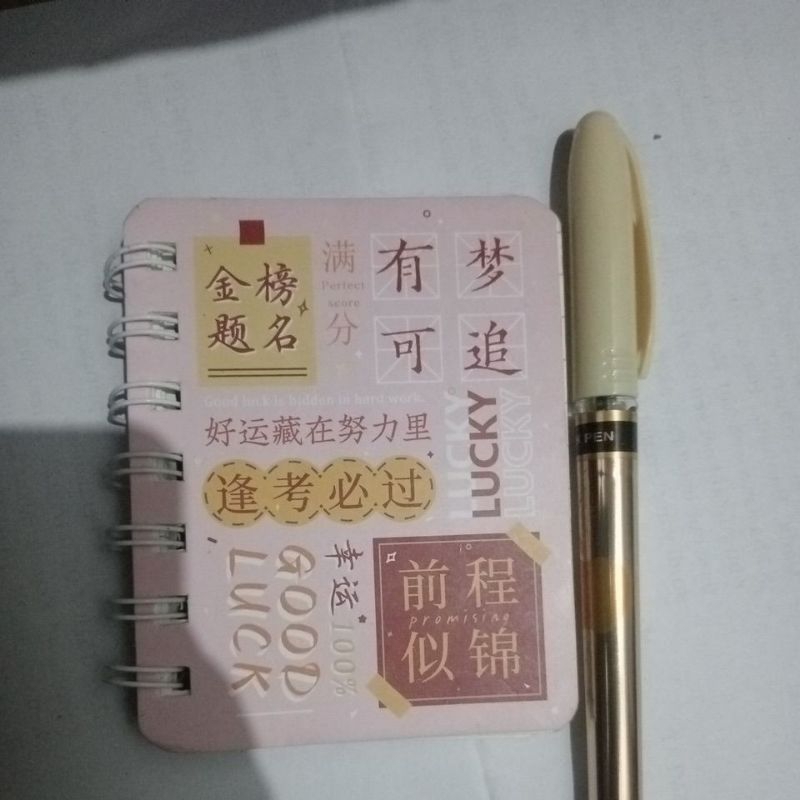 

buku kecil dan bolpoin.