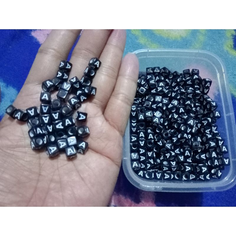 manik manik Mote huruf A kotak hitam tulisan putih