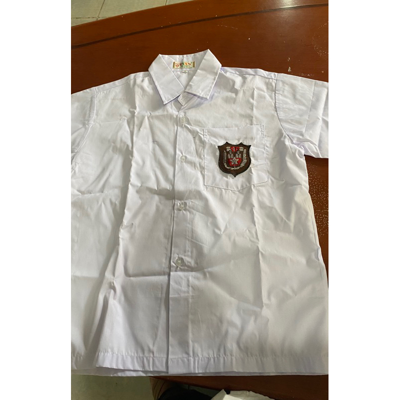 Seragam putih ada bercak tinta dan bekas jahitan di tangan