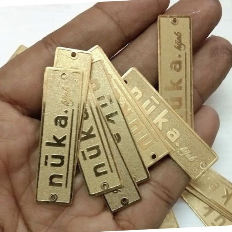 

LABEL PLAT HIJAB MOTIF KULIT JERUK BAHAN KUNINGAN HARGA PER 100 PCS FRE DESAIN LOGO