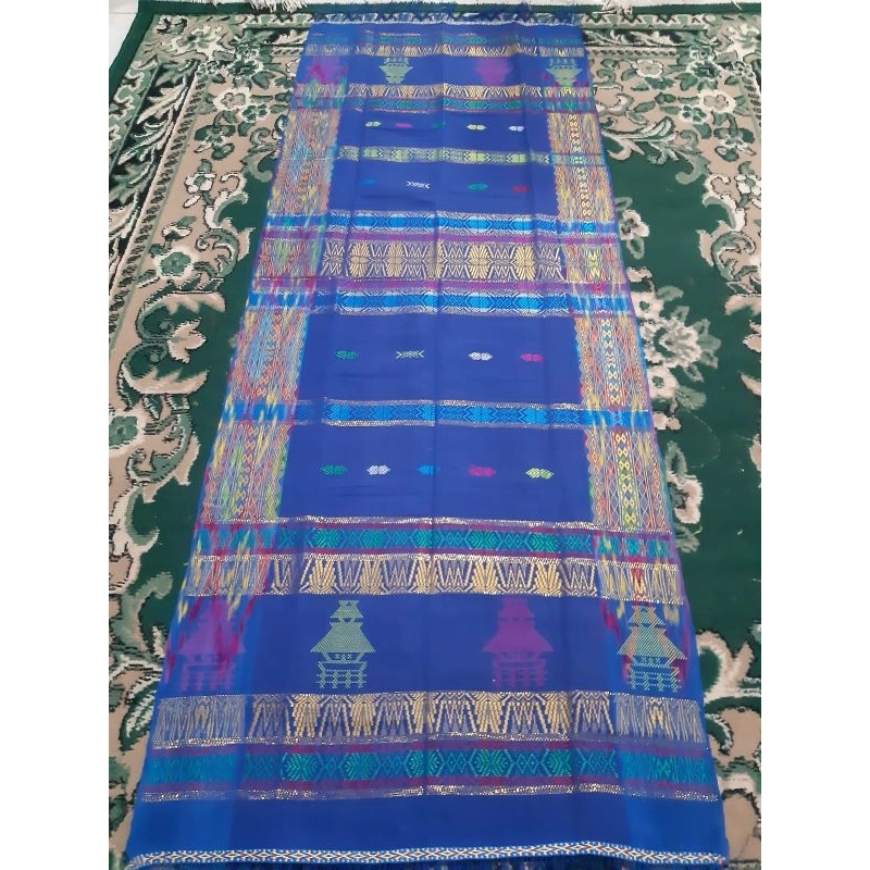 Uis Nipes Biru Gatip Pinggir Rumah Adat