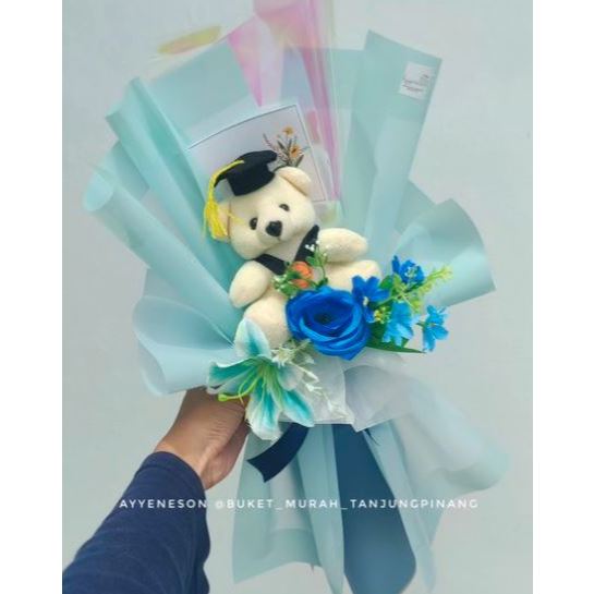 Buket Boneka Wisuda Putih dan Bunga Biru Kertas Warna Biru