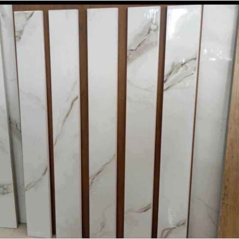 plint granit 10x60 putih motip calacata