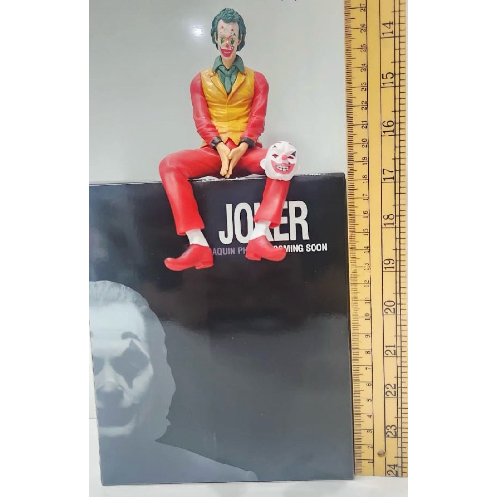 action figure joker baju merah duduk