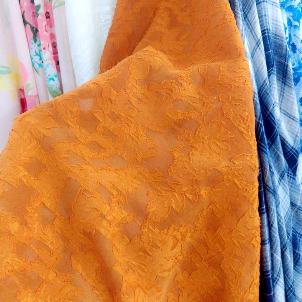 Kain Brokat Motif Bunga Timbul Warna Oranye – Elegan untuk Kebaya & Dress Harga Per½ Meter