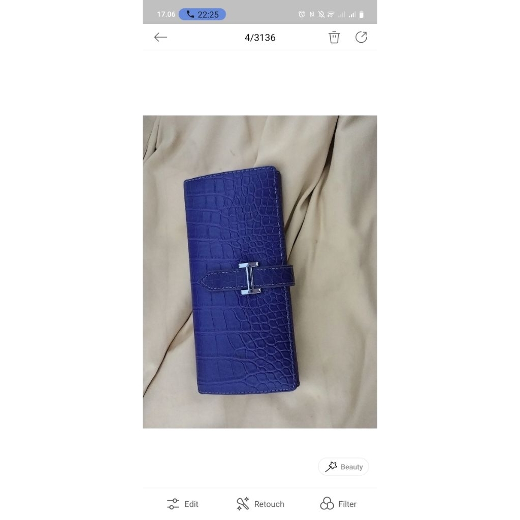 dompet panjang Hermes Bearn Soufflet berwarna biru dengan hardware perak. 