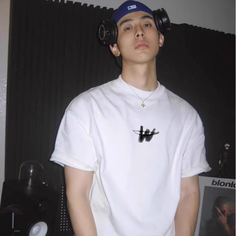 Kaos lengan pendek loose dengan logo huruf "W" di tengah dari WE11DONE TRACK, dengan desain logo hur