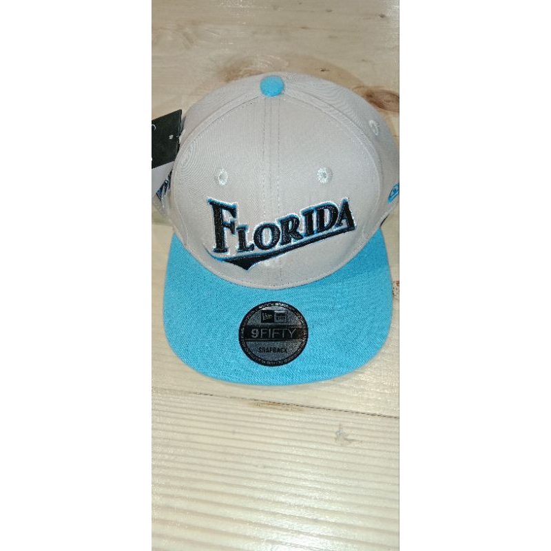 Topi Snapback warna Cream dan biru tosca ada bordir.