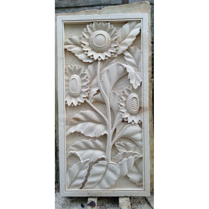 relief ukir motif bunga matahari dan bunga teratai