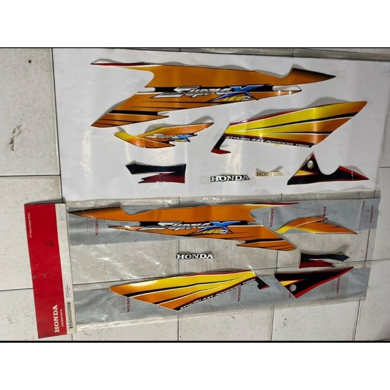 STRIPING BODY SUPRA X125D LAMA ORIGINAL AHM