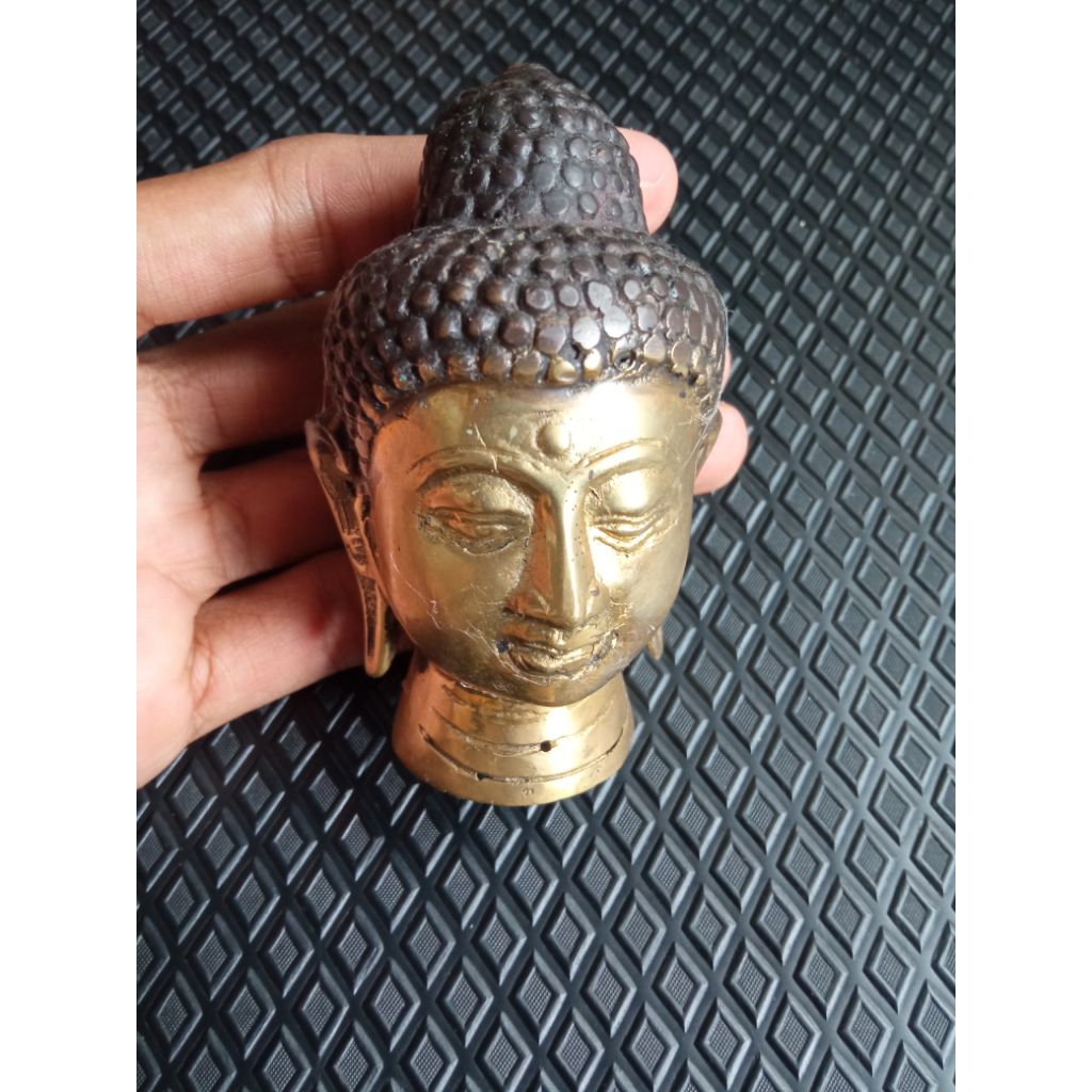 patung kepala Buddha logam