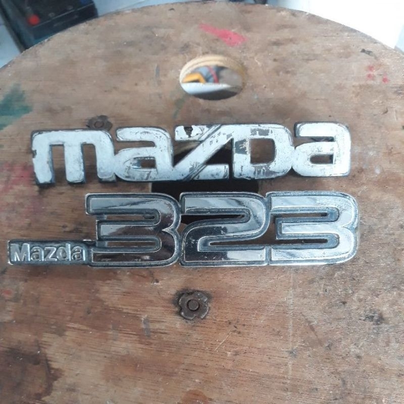 emblem bagasi Mazda 323 trendy elite