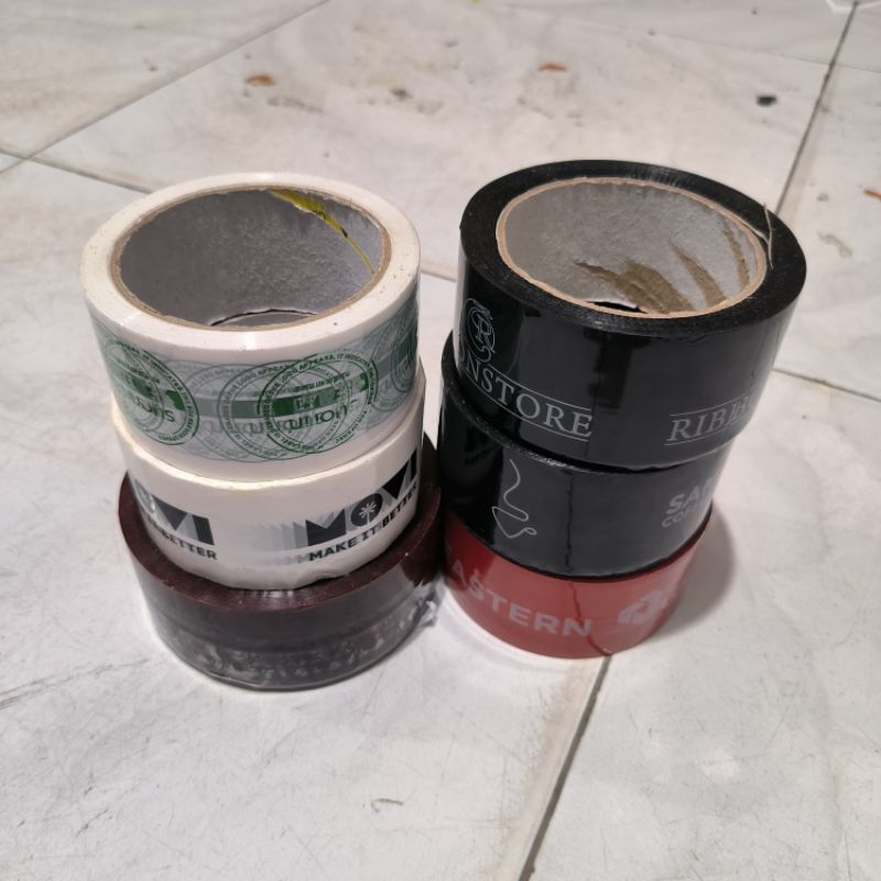 

Lakban Kiloan printing layak pakai 1 kg isi 5-8 roll plakban packing rijek murah