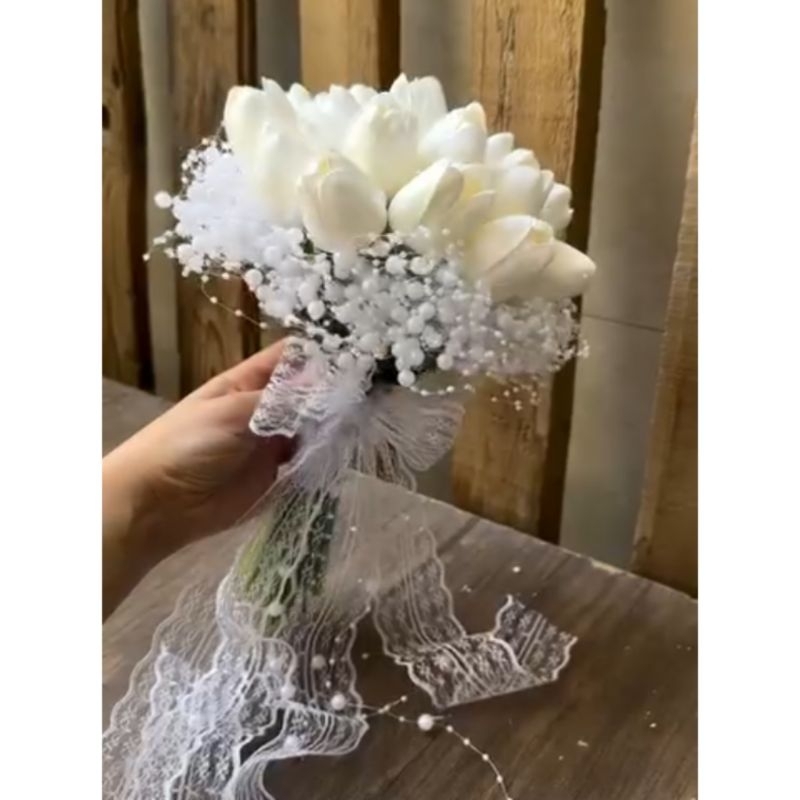 Hand bouquet bunga tulip dengan hiasan mutiara