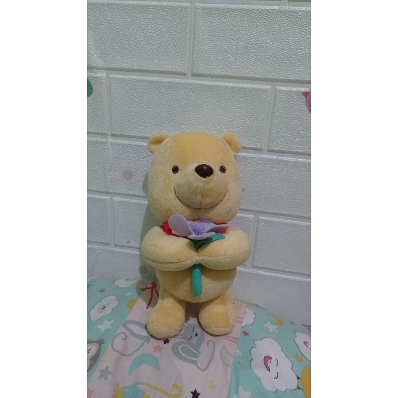 boneka kecil pooh membawa bunga