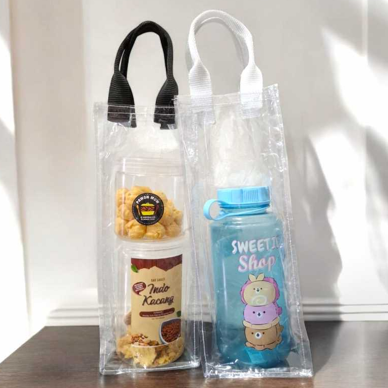 

Tas Botol 2 Liter Mika Transparan Uk 12 x 12 x 32 cm (Polos/Tanpa Sablon) Tali Webbing Tebal PVC 0.2 Tas Hampers Lebaran Hadiah Tas Toples