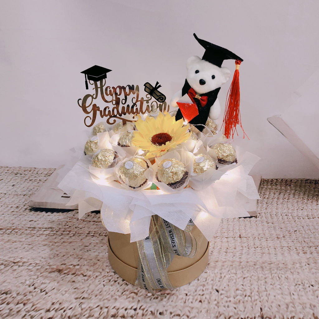 

Bloombox Wisuda Coklat Ferrero - Bunga Matahari - Boneka Wisuda -Hadiah Graduation HW027