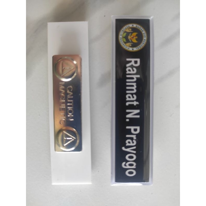 

Nametag Pakai Logo Badan Gizi Nasional BGN Font dan List Putih Background Hitam