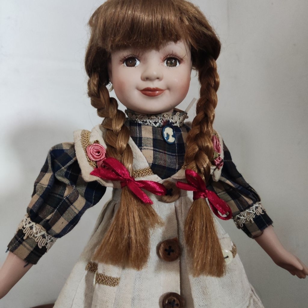 Porcelain Doll Girl with Braided Hair in a Plaid Blue Dress and Apron. Boneka Porselen Keramik