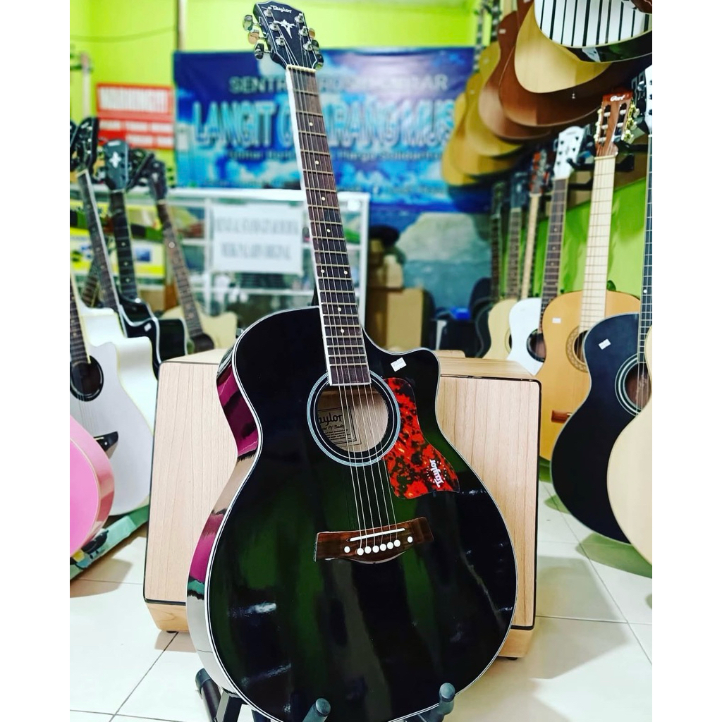 Gitar Akustik Taylor warna hitam dengan soundhole roset merah, model cutaway