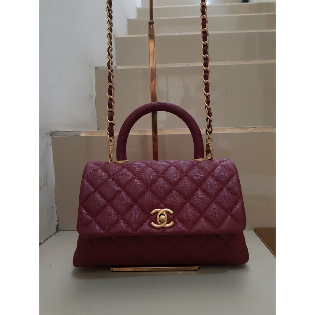 Burgundy Chanel Coco Handle bag is crafted from quilted caviar leather and features distinct gold-to