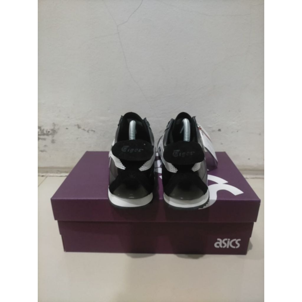 sepatu Onitsuka Tiger Mexico 66 berwarna hitam dengan strip putih.