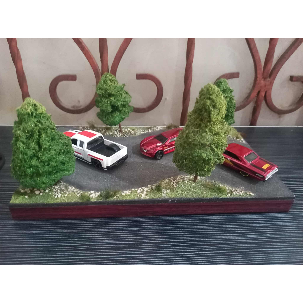 Diorama jalanan aspal dengan ddihiasi Pohon cemara