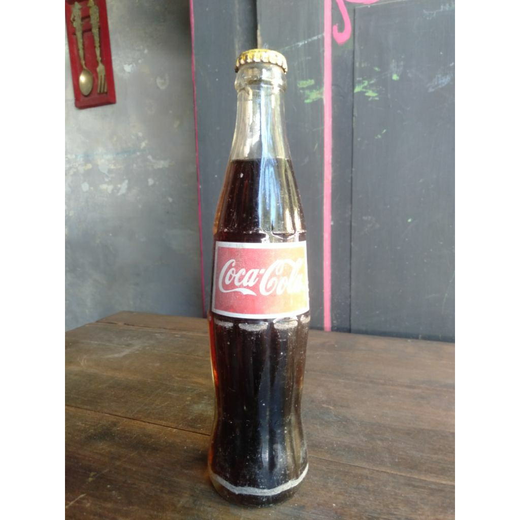 Botol kaca klasik Coca-Cola ini memiliki desain kontur khas yang ikonik